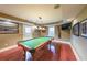 Basement includes a pool table with light fixtures, wood floor, and a mounted television for entertainment at 5323 Lakesprings Dr, Dunwoody, GA 30338