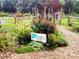 View of a Dunwoody Community Garden with a variety of flowering plants and mulch paths at 5323 Lakesprings Dr, Dunwoody, GA 30338