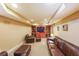 Basement living room features a large leather sofa, matching armchairs, and built-in shelving with a TV at 5323 Lakesprings Dr, Dunwoody, GA 30338