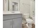 Bathroom featuring a grey vanity with white countertop, mirror and toilet near a white shower and tub at 7744 Fawn Cir, Covington, GA 30014