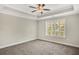 Bright bedroom with plush carpeting, a ceiling fan, and a view of the neighborhood at 7744 Fawn Cir, Covington, GA 30014