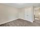 Bedroom featuring neutral walls, carpet floors, and a large double-door closet, showcasing a simple design at 7744 Fawn Cir, Covington, GA 30014