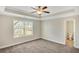 Bright bedroom with plush carpeting, a ceiling fan, and a window offering neighborhood views at 7744 Fawn Cir, Covington, GA 30014