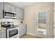 Galley kitchen featuring stainless steel appliances, granite countertops, and access to the exterior at 7744 Fawn Cir, Covington, GA 30014