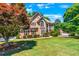 Two story house with tan siding, brown roof, and burgundy shutters at 234 Lake Ruby Dr, Suwanee, GA 30024