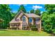Two story house with tan siding, brown roof, and burgundy shutters at 234 Lake Ruby Dr, Suwanee, GA 30024