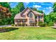Two story house with tan siding, brown roof, and burgundy shutters at 234 Lake Ruby Dr, Suwanee, GA 30024