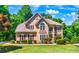 Two story house with tan siding, brown roof, and burgundy shutters at 234 Lake Ruby Dr, Suwanee, GA 30024