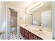 Primary bathroom with double sink vanity, large mirror and tile floor at 2400 Stedman Sw Ln, Conyers, GA 30094