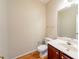Half bathroom features wooden floors, white toilet and vanity with sink at 2400 Stedman Sw Ln, Conyers, GA 30094