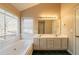 Bathroom showcasing a soaking tub, double vanity sink, and large window at 2400 Stedman Sw Ln, Conyers, GA 30094