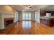 Open-concept living room with hardwood floors, brick fireplace, and adjacent kitchen bar area at 2400 Stedman Sw Ln, Conyers, GA 30094