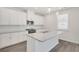 Modern kitchen with white cabinets, granite island, and stainless steel appliances at 3208 Shirecrest Ln, Dacula, GA 30019