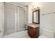 Bathroom featuring tile floors, shower-tub combo with glass door and single sink vanity at 3245 Buckhead Forest Ne Mews, Atlanta, GA 30305