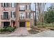 Charming brick townhome featuring black shutters, a yellow front door, and a well-manicured front yard at 3245 Buckhead Forest Ne Mews, Atlanta, GA 30305
