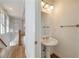 Powder room with pedestal sink and decorative lighting next to the stairwell at 3245 Buckhead Forest Ne Mews, Atlanta, GA 30305