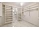 Large walk-in closet with custom shelving and drawers, illuminated by a stylish chandelier at 3245 Buckhead Forest Ne Mews, Atlanta, GA 30305