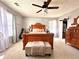 Main bedroom with wooden bed frame, ceiling fan and dresser at 5485 Mountain Top Pl, Cumming, GA 30041