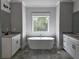Finished bathroom featuring a soaking tub, granite vanities, and a window at 6851 Phillips Mill Rd, Douglasville, GA 30135