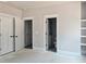 Bedroom with gray walls, white trim, open closet, and doorway to the bathroom at 6851 Phillips Mill Rd, Douglasville, GA 30135