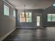 Elegant dining room with modern lighting and backyard access through a glass door at 6851 Phillips Mill Rd, Douglasville, GA 30135