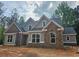 Charming new home with stone accents and light gray siding nestled among mature trees at 6851 Phillips Mill Rd, Douglasville, GA 30135