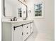 Modern bathroom with double vanity, updated fixtures and marble-look floor at 2736 Joyce Ave, Decatur, GA 30032