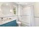 Stylishly renovated bathroom with a blue vanity, marble countertop, and tiled tub and shower combo at 3180 Arden Nw Rd, Atlanta, GA 30305