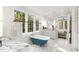 Bright bathroom featuring a clawfoot tub, marble countertops, and natural light from large windows at 3180 Arden Nw Rd, Atlanta, GA 30305