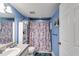 Clean bathroom with shower, storage, and a floral shower curtain at 446 Mcgukin Rd, Bremen, GA 30110