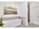 White bathroom with a soaking tub, wainscoting, a stone-look shower, and tile floors at 204 Dawson Dr, Woodstock, GA 30188