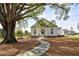 Charming white home with stone path and a large, mature tree in a manicured lawn at 204 Dawson Dr, Woodstock, GA 30188