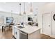 Open kitchen featuring white cabinets, stainless appliances, island seating, flowing into dining and living areas at 204 Dawson Dr, Woodstock, GA 30188