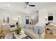 Bright living room with hardwood floors, neutral furniture, modern ceiling fan, and staircase at 204 Dawson Dr, Woodstock, GA 30188