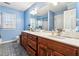 Bathroom boasts double vanity, wood cabinets, and blue walls at 24 Planters Sw Dr, Lilburn, GA 30047