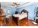 Blue bedroom with hardwood floors, ceiling fan, and large bed at 24 Planters Sw Dr, Lilburn, GA 30047