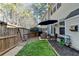 Backyard with artificial turf, fence, and outdoor seating under a blue umbrella at 221 Kenninghall Se Ln, Smyrna, GA 30082