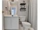 Neutral bathroom with a toilet, vanity, mirror, and patterned shower curtain at 221 Kenninghall Se Ln, Smyrna, GA 30082