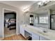 Bathroom with double sink vanity, large mirror, and a view into the main bedroom at 221 Kenninghall Se Ln, Smyrna, GA 30082