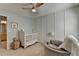 Bedroom with a white crib, chair, and stylish wall paneling at 221 Kenninghall Se Ln, Smyrna, GA 30082