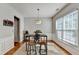 Sunlit dining area features a table set for four and hardwood floors at 221 Kenninghall Se Ln, Smyrna, GA 30082