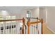 Upstairs hallway with hardwood floors and railing at 2265 Wildwood Lake Dr, Suwanee, GA 30024