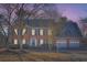 Brick two-story house with a two-car garage, illuminated at dusk at 3422 Sweetbriar Ln, Powder Springs, GA 30127