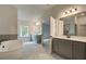 Bathroom with double vanity, large mirror, and a view of the bedroom at 512 Dolce Rd, Locust Grove, GA 30248