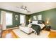 Comfortable bedroom featuring an accent wall, a ceiling fan, hardwood floors, and ample natural light from two windows at 15 Kings Tavern Nw Pl, Atlanta, GA 30318