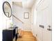 Inviting hallway with wood floors, a staircase, and a sleek black console table with a modern mirror at 15 Kings Tavern Nw Pl, Atlanta, GA 30318