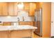 Well-lit kitchen featuring stainless steel refrigerator, light wood cabinetry, granite countertops, and subway tile backsplash at 15 Kings Tavern Nw Pl, Atlanta, GA 30318