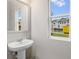 Simple bathroom with pedestal sink, framed mirror, and large window at 5591 Hislop Lane # 77, Mableton, GA 30126