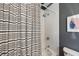 Updated bathroom with a shower featuring stylish tile, a patterned shower curtain, and neutral paint at 66 Howell Ne St, Atlanta, GA 30312