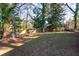 View of the spacious back yard with mature trees and a fence at 3448 Montreal Way, Tucker, GA 30084